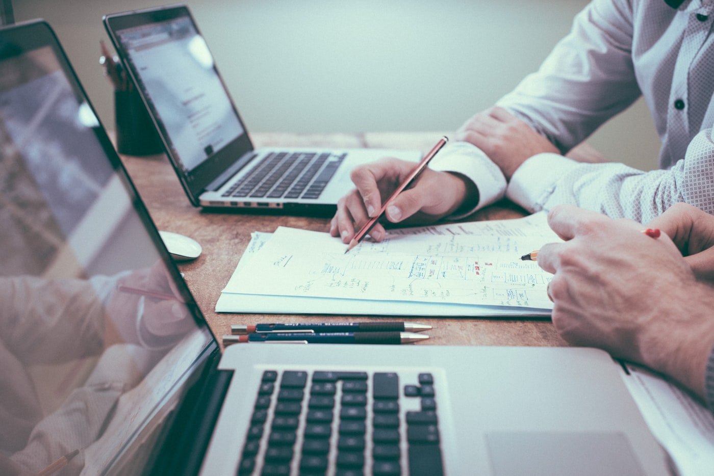 A freelancer reviewing financial documents at a desk with a laptop